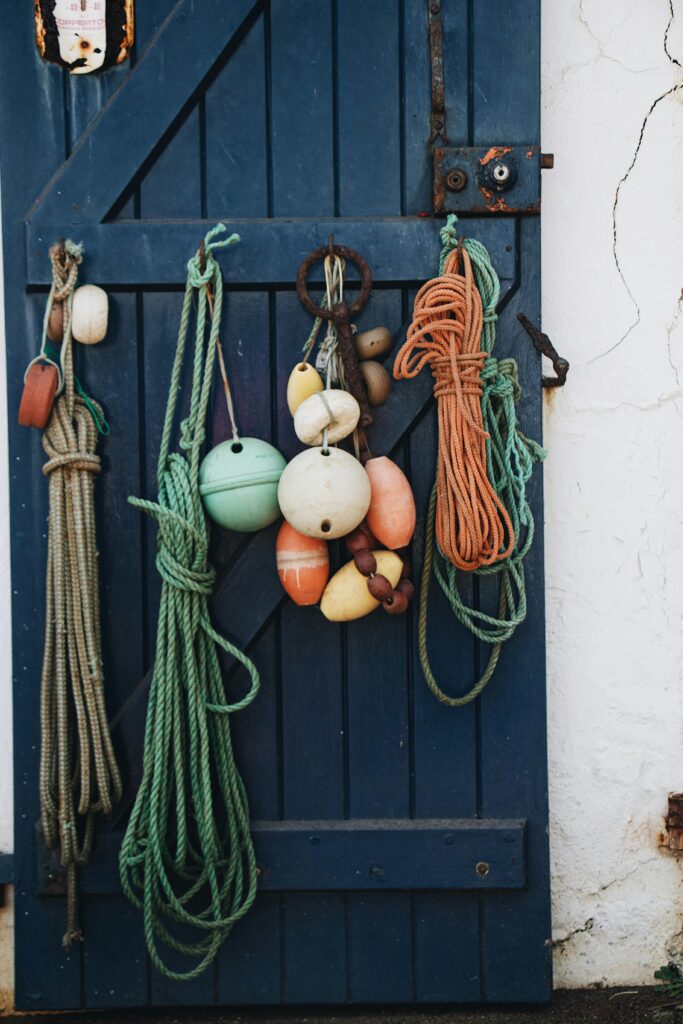 Rope Knots and Buoys Hanging from Blue Wooden Doors